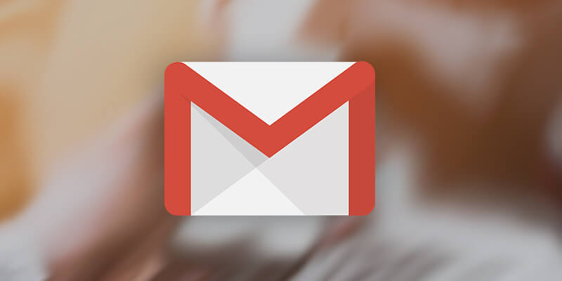 Developers reading messages in a blurry behind Gmail logo