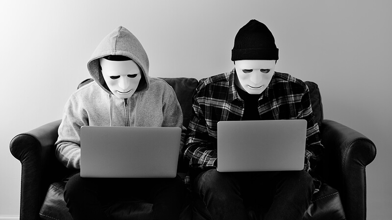Two hackers with mask on an identity theft